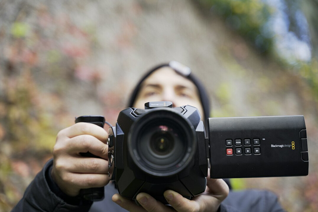 Camera operator filming a live news segment with a professional broadcast camera